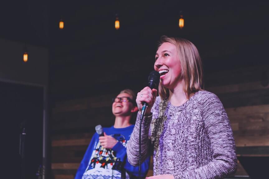 Team singing at a mic