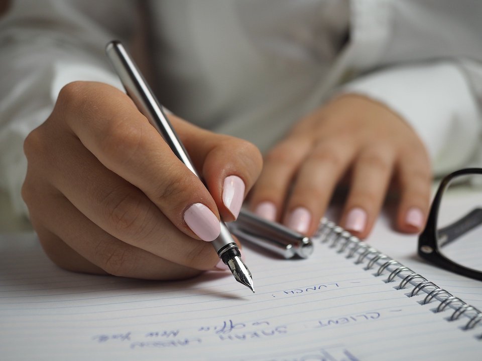 Person writing down a schedule for an event